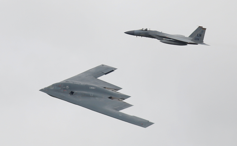 A B-2 Spirit bomber flying alongside a F-15C Eagle, 2017.
